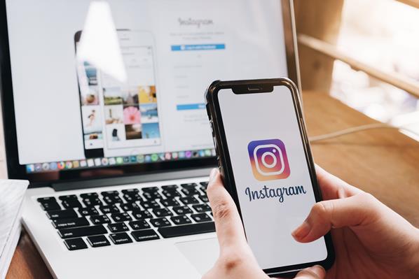 Instagram user on phone and laptop