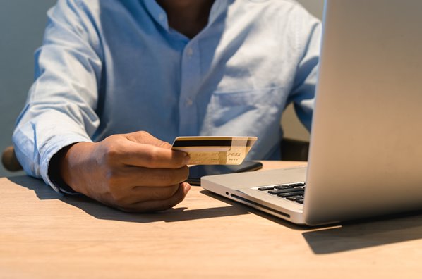 Customer paying with credit card on his laptop