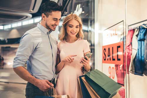 Couple using mobile while shopping